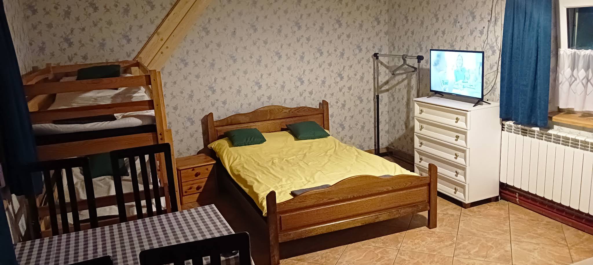 Pokój gościnny z drewnianym łóżkiem przy oknie