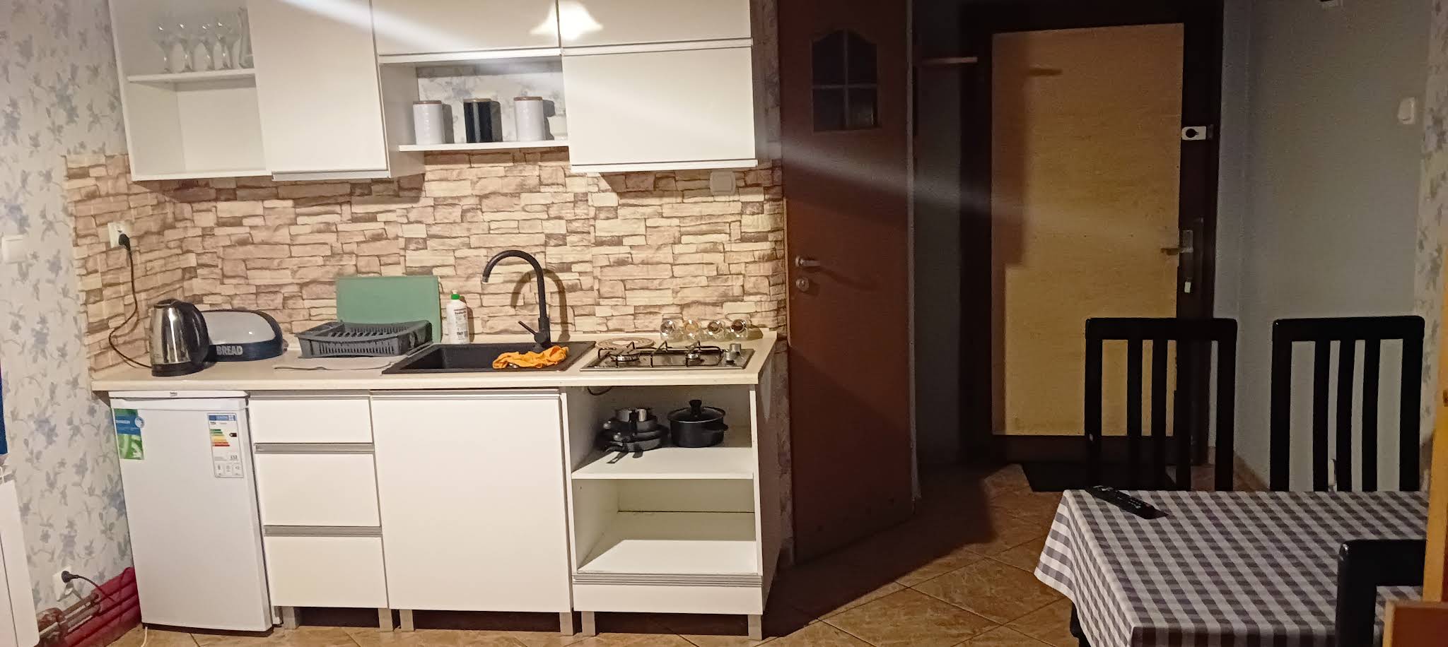 Zadaszone wejście do drewnianego domku z widokiem na zieleń